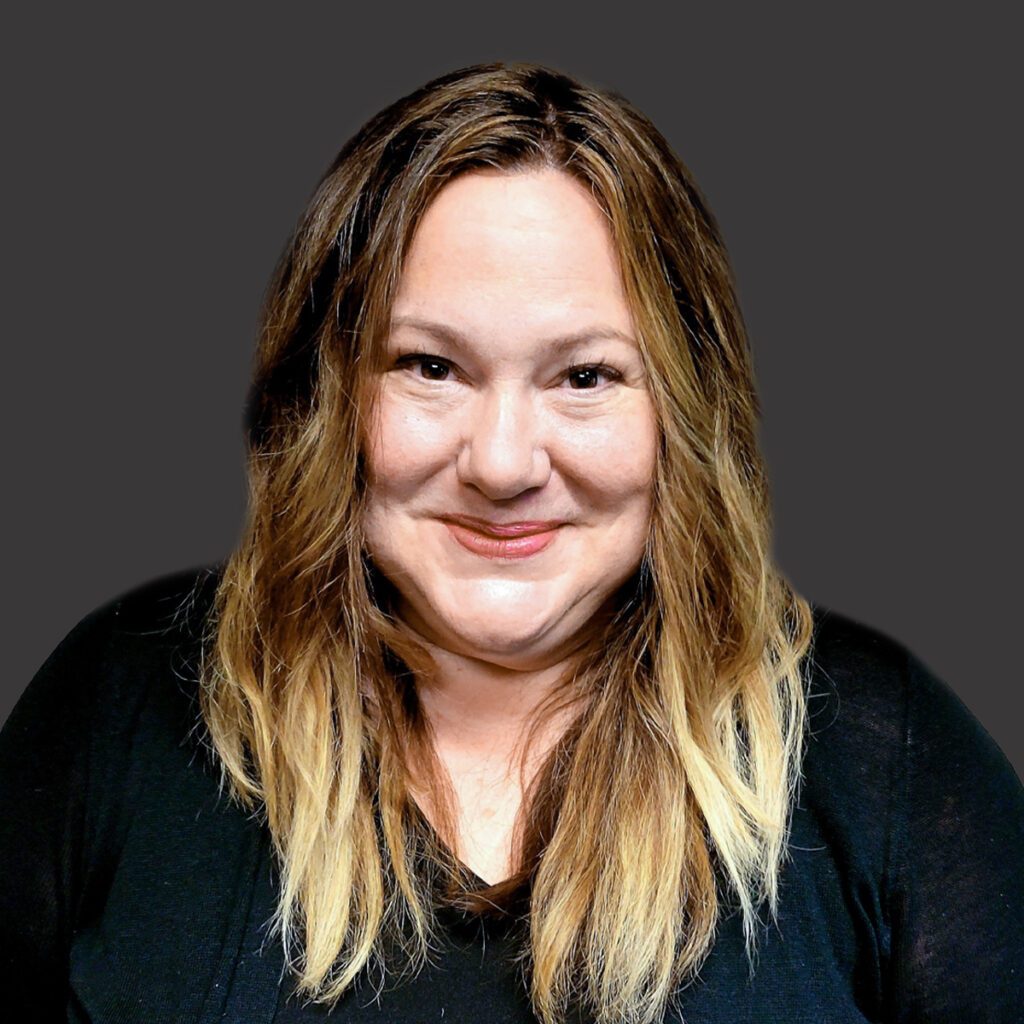 a professional headshot of sara willy with a gray background