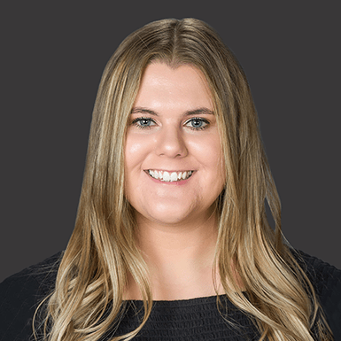 a professional headshot of kelsey collins with a gray background