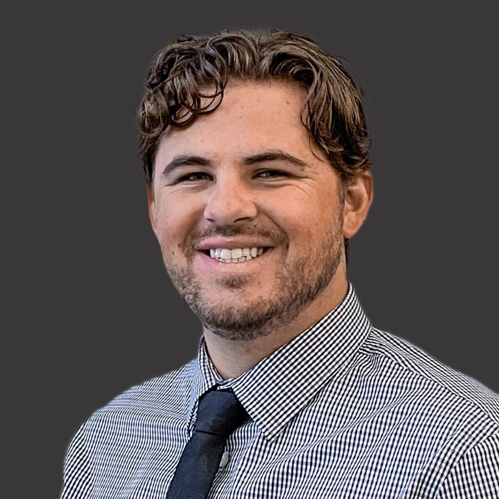 a professional headshot of spencer felkins with a gray background